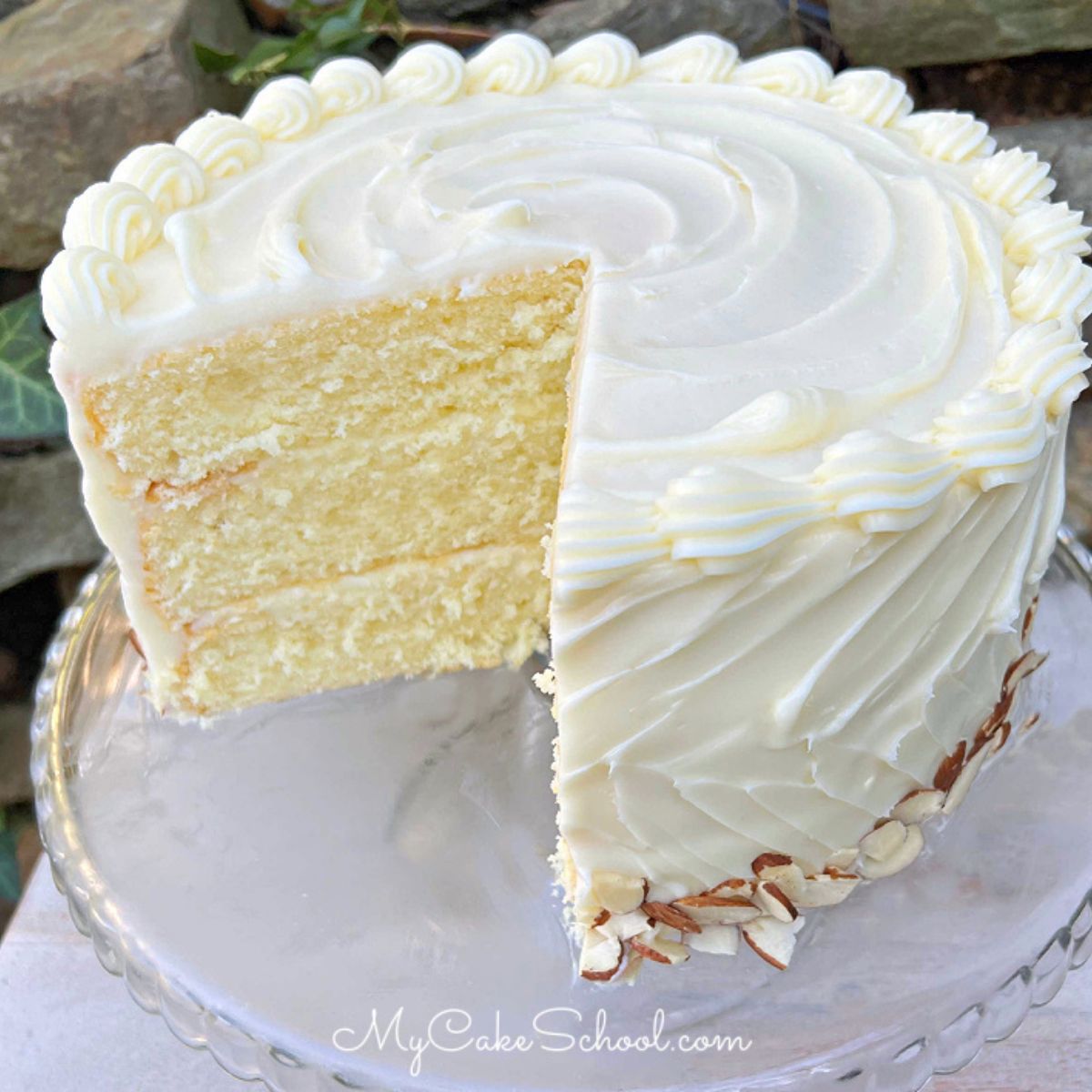 Moist Almond Cream Cake, sliced, on a pedestal