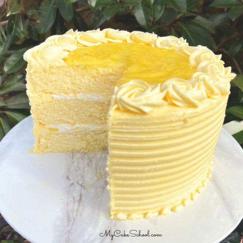 Lemon Velvet Cake, sliced, on a cake pedestal.