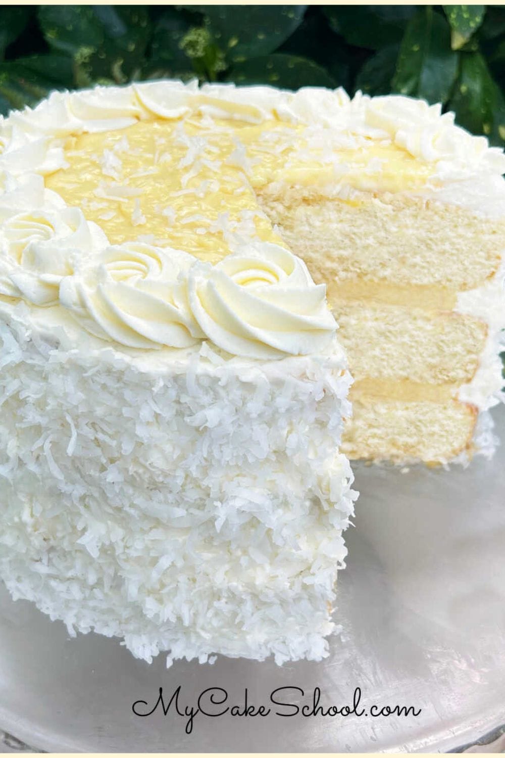 Sliced Coconut Cream Cake on a cake pedestal.