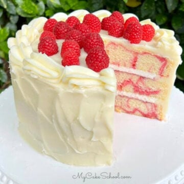 Sliced Almond Raspberry Swirl Cake on a white pedestal