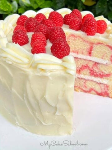 Sliced Almond Raspberry Swirl Cake on a white pedestal