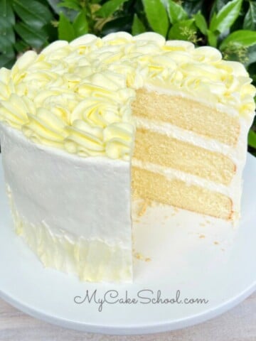 Sliced Limoncello Cake on white cake pedestal.