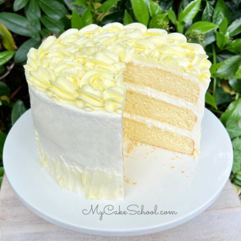 Sliced Limoncello Cake on white cake pedestal.