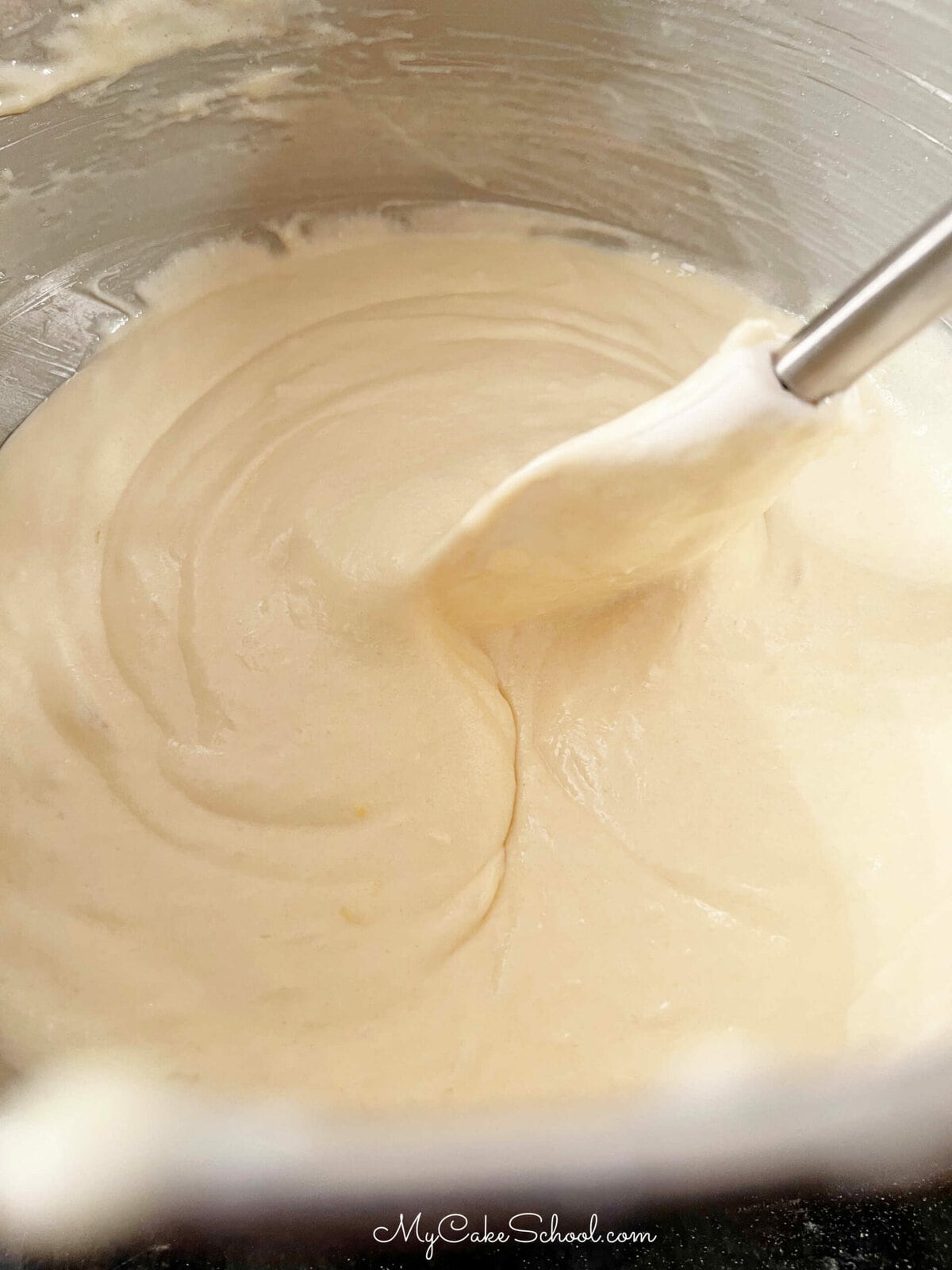 Cake Batter in mixing bowl with spatula.