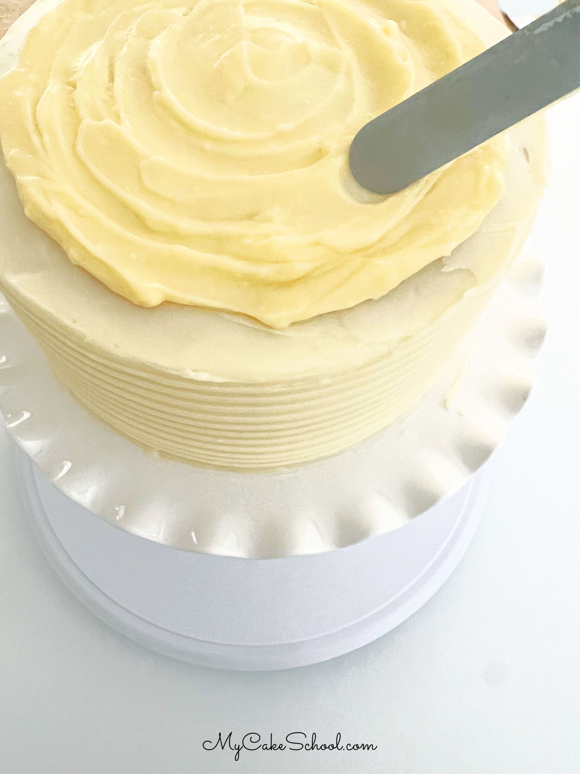 Adding Banana Cream Filling to the top of the Banana Cake with a small offset spatula.
