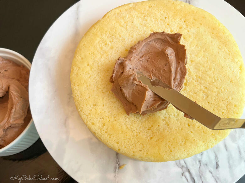 Applying frosting to Yellow Velvet Cake