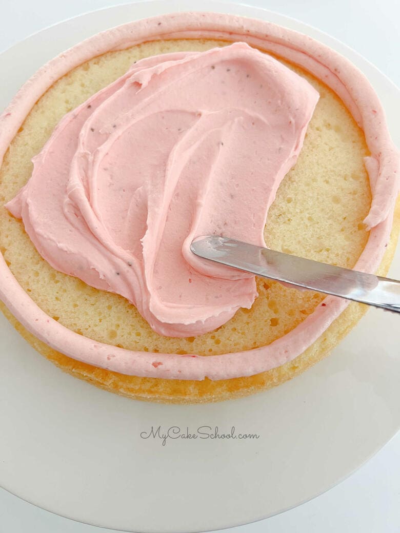Spreading strawberry mousse onto cake layer