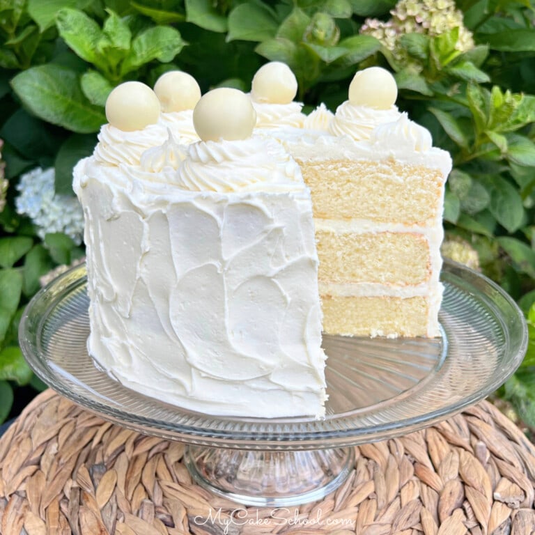 Sliced White Chocolate Cake on a pedestal.