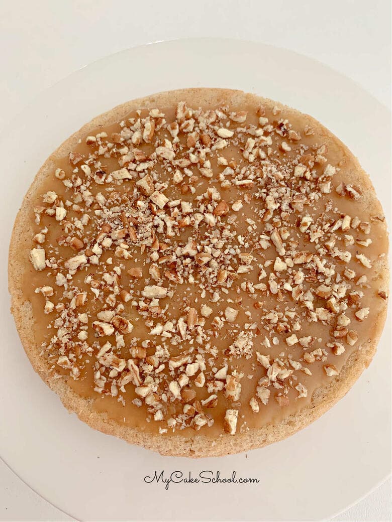 Caramel glazed apple cake layer topped with pecans