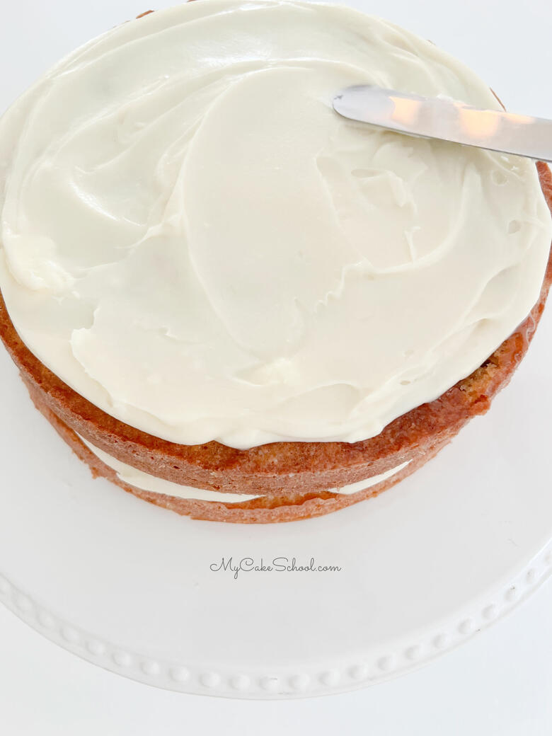 Spreading layer of cream cheese over the caramel glazed layer.