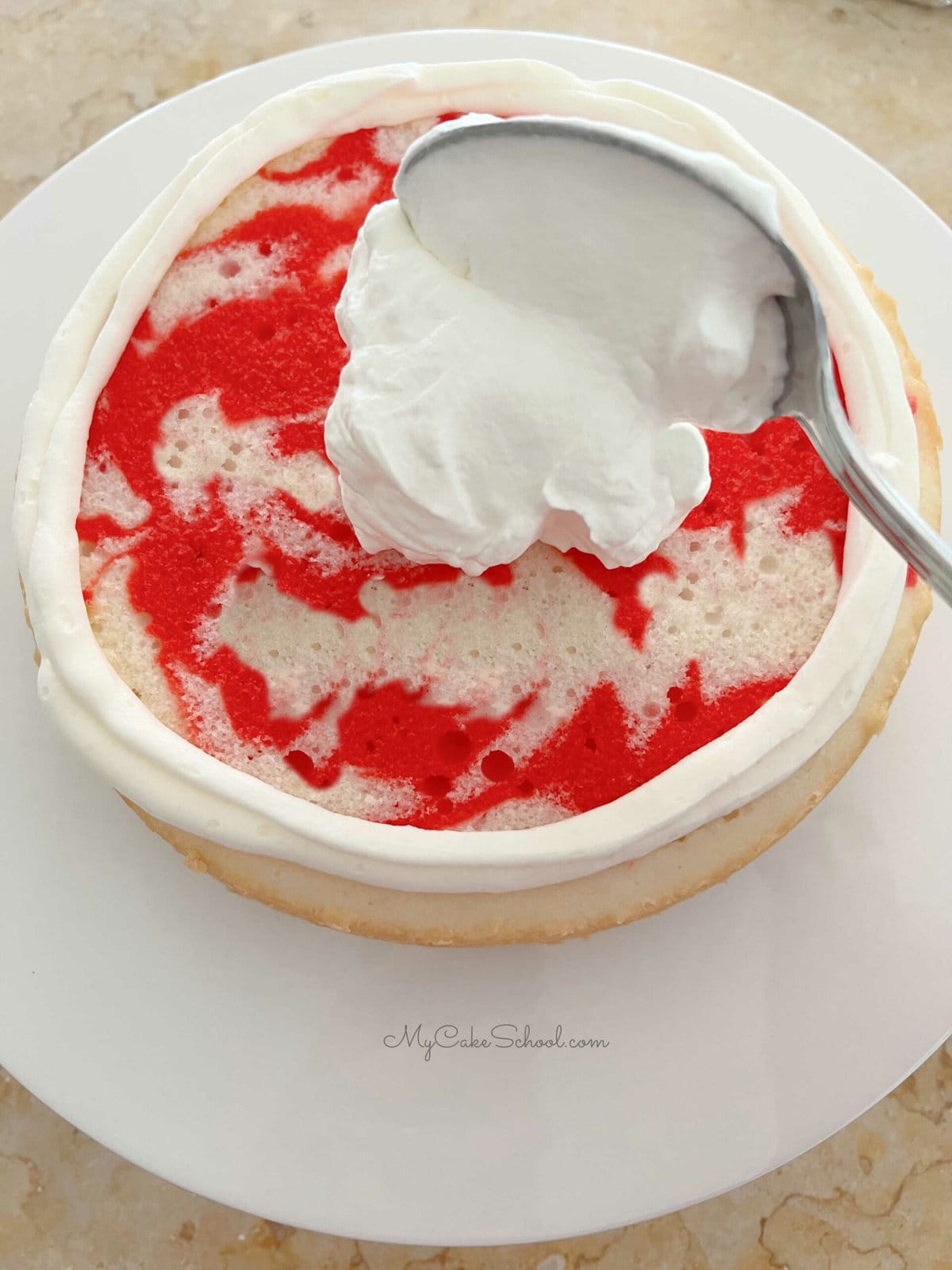 Spreading Peppermint Whipped Cream onto Peppermint Cake Layers