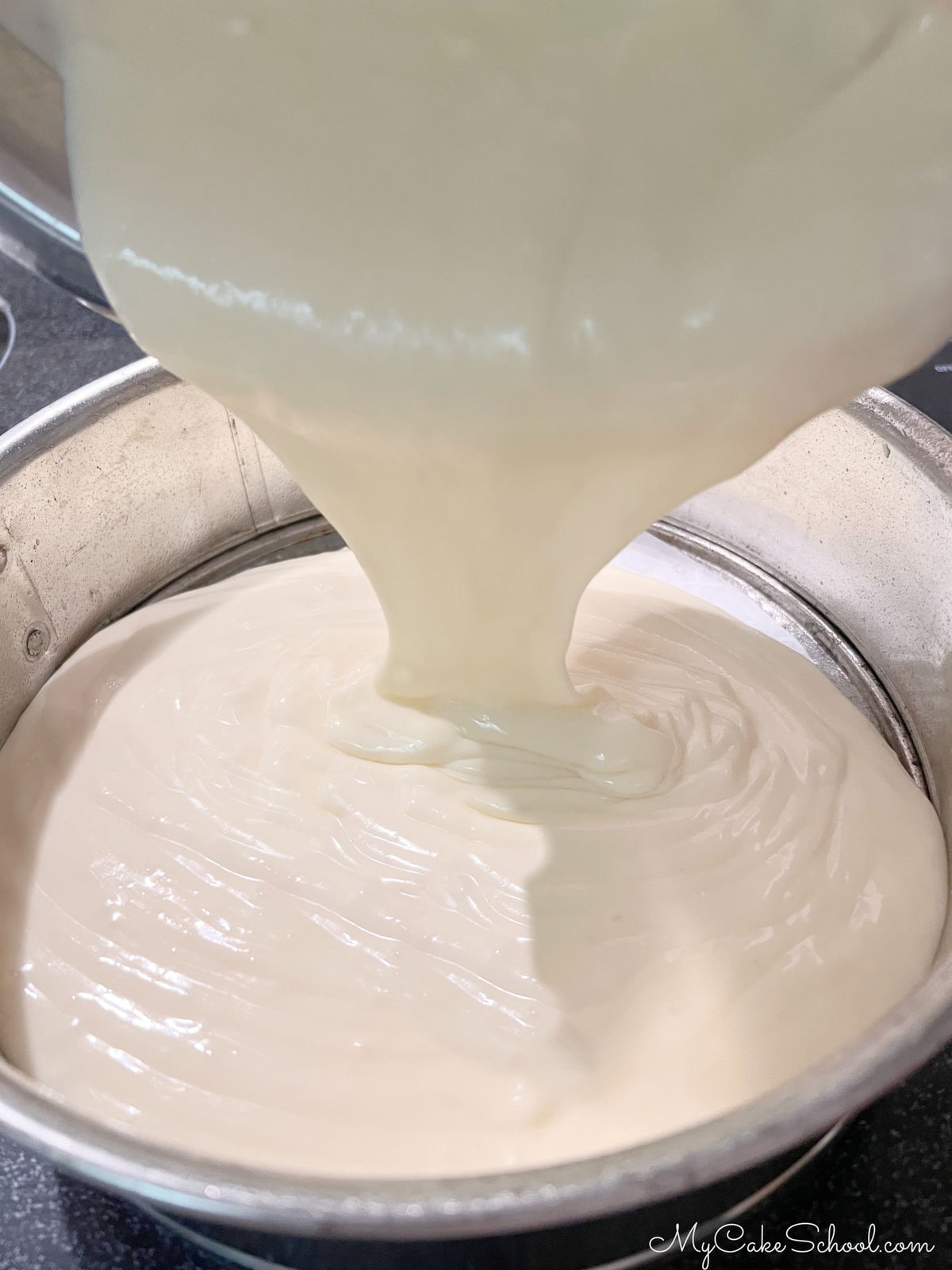 Pouring the cheesecake batter into parchment-lined springform pan