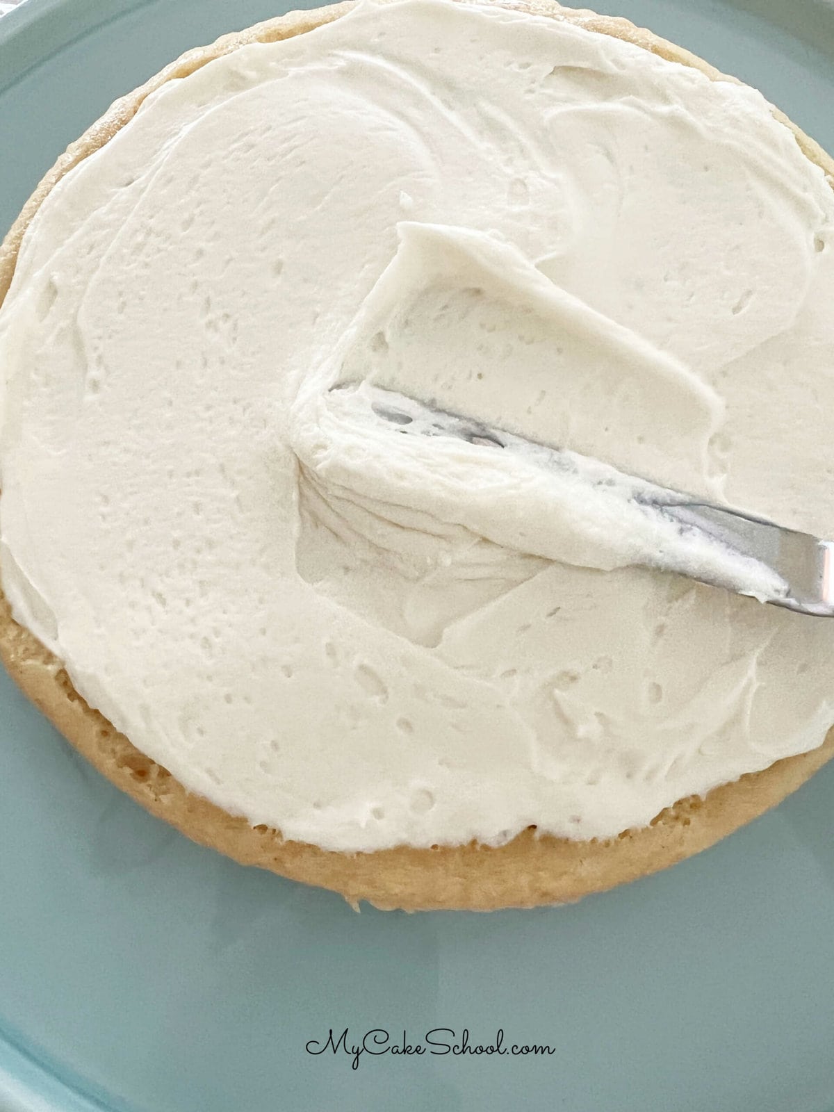 Applying frosting to the first cake layer