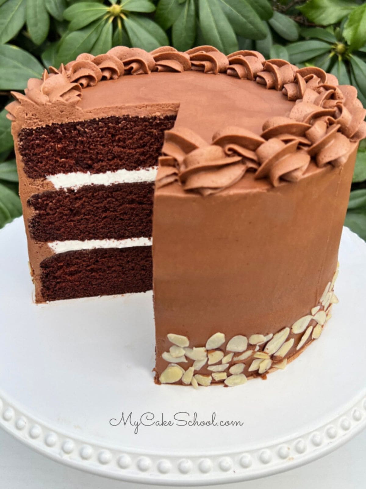 Sliced Chocolate Almond Cake on a cake pedestal.