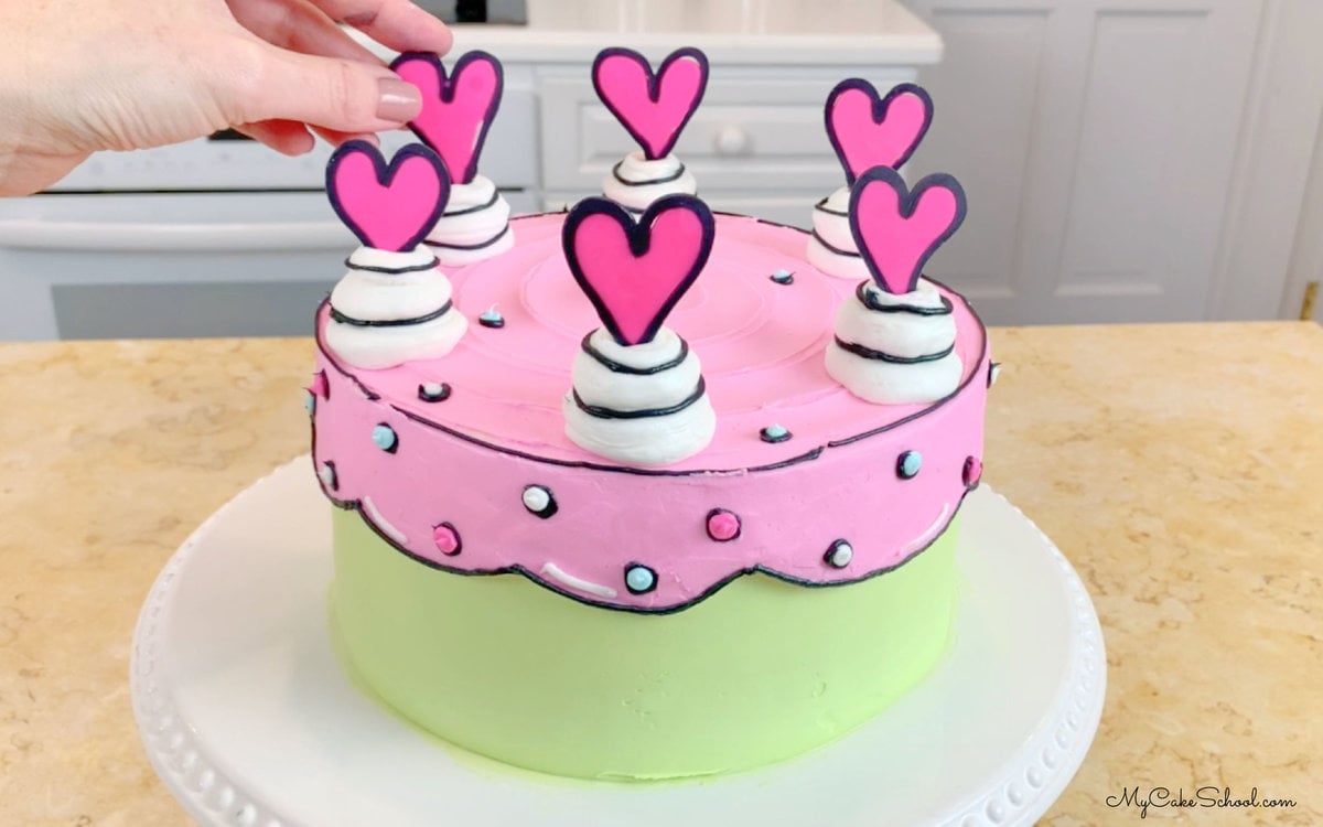 Topping the decorated cake with chocolate hearts
