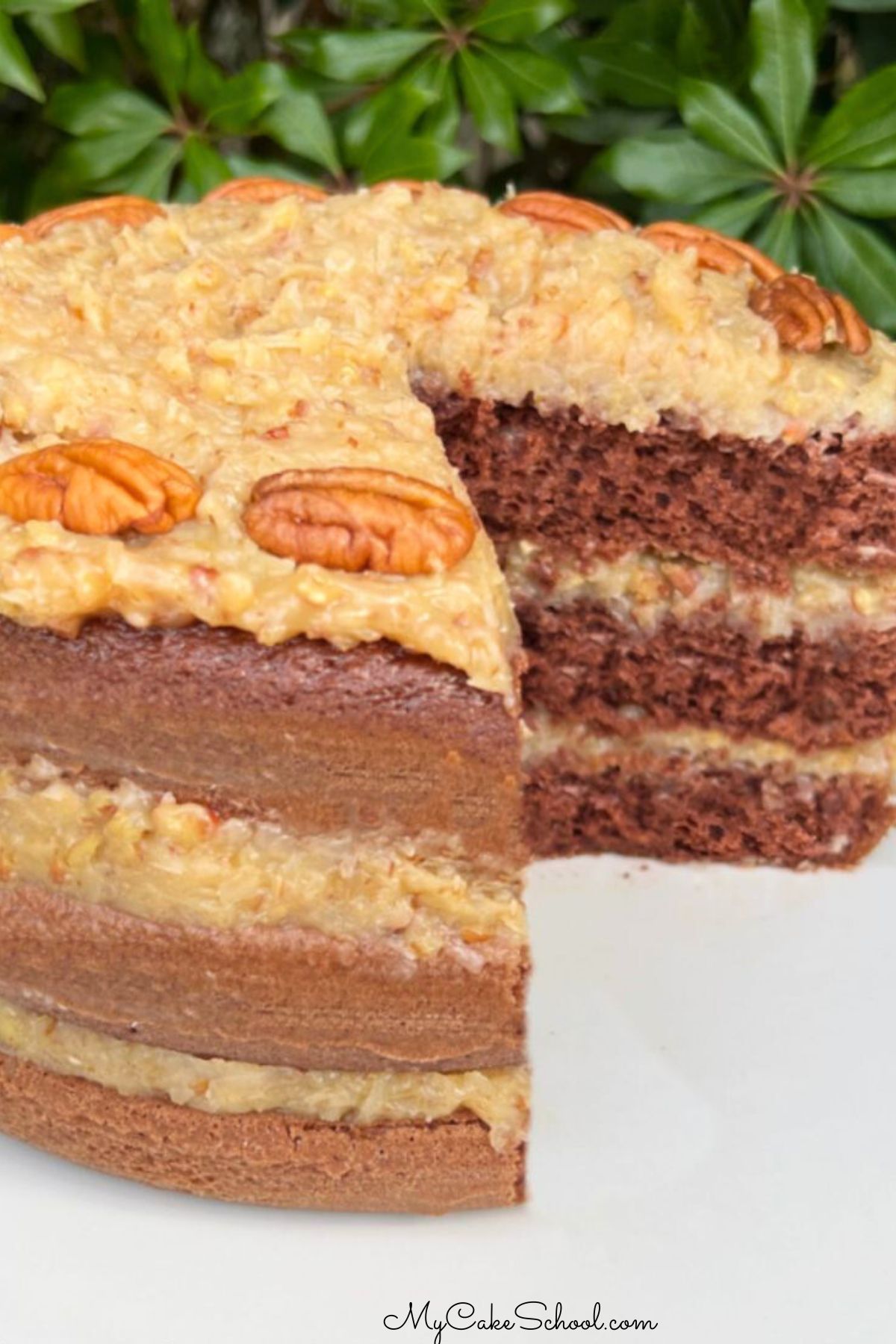 Sliced German Chocolate Cake from cake mix, on a white pedestal.