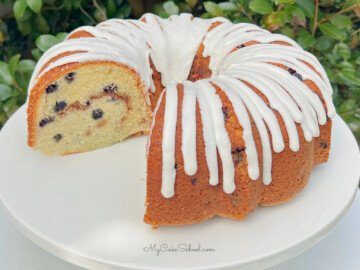 Glazed Blueberry Bundt Cake on a white pedestal