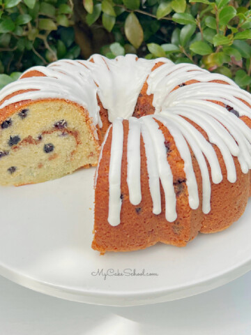 Glazed Blueberry Bundt Cake on a white pedestal