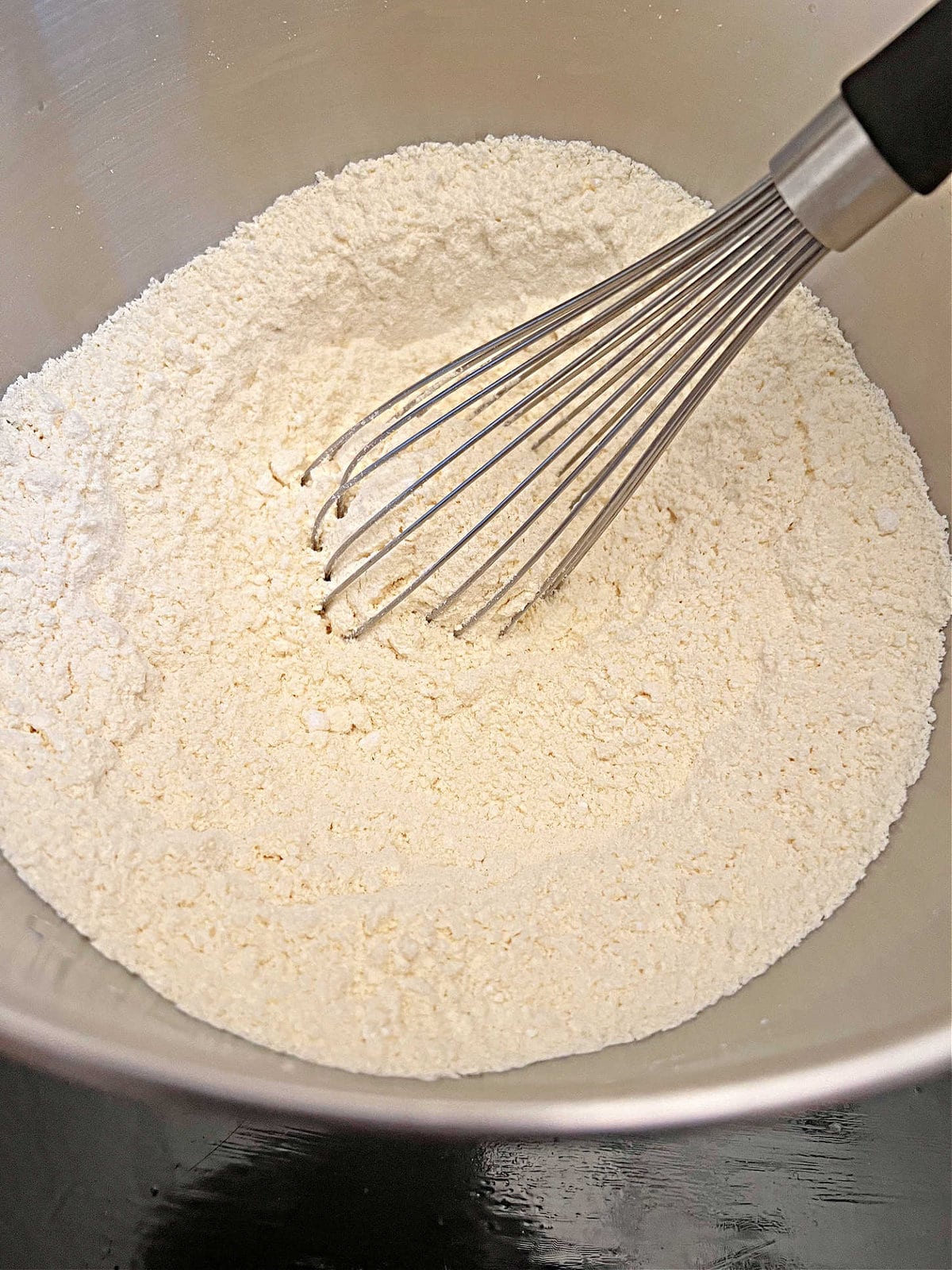 Dry cake ingredients in a silver mixing bowl