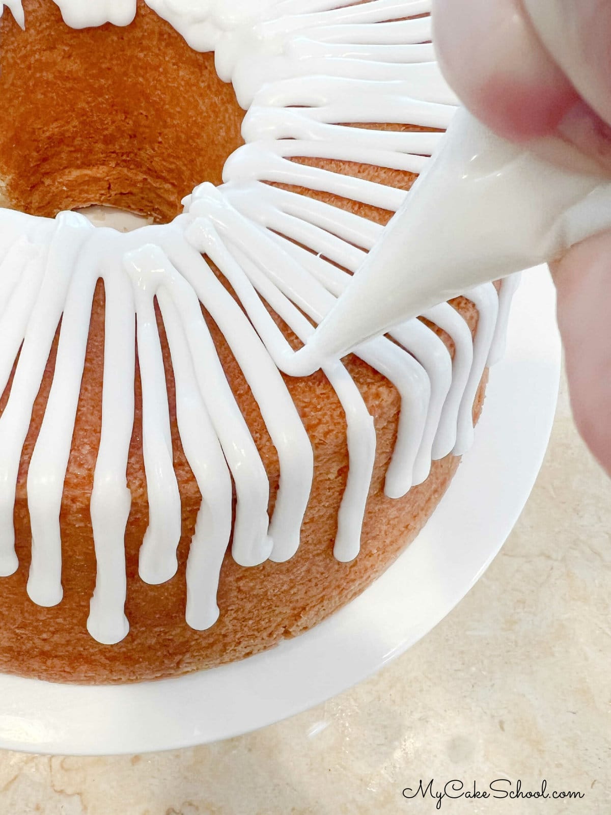 Applying Coconut Glaze to Pound Cake with Piping Bag