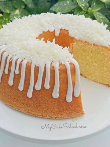Lemon Coconut Pound Cake, sliced, on a cake pedestal.