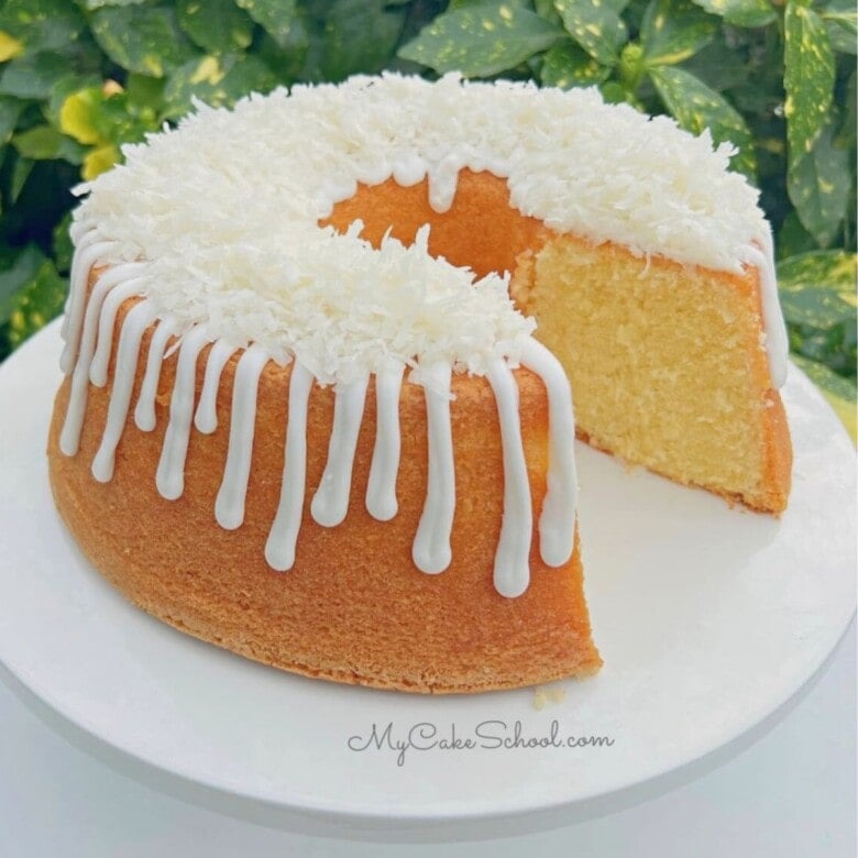 Lemon Coconut Pound Cake, sliced, on a cake pedestal.