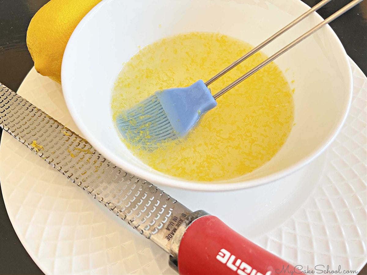 Bowl of Lemon Simple Syrup with a pastry Brush 