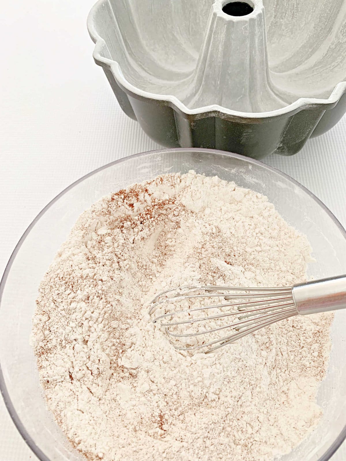 Dry ingredients for Hummingbird Bundt Cake in a bowl with whisk