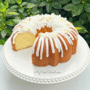 Almond Coconut Bundt Cake, sliced, on a white pedestal