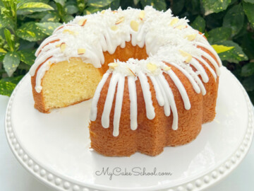 Almond Coconut Bundt Cake, sliced, on a white pedestal