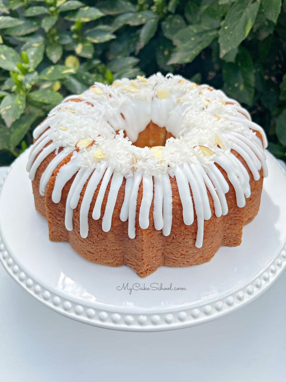 Glazed Almond Coconut Bundt Cake on pedestal