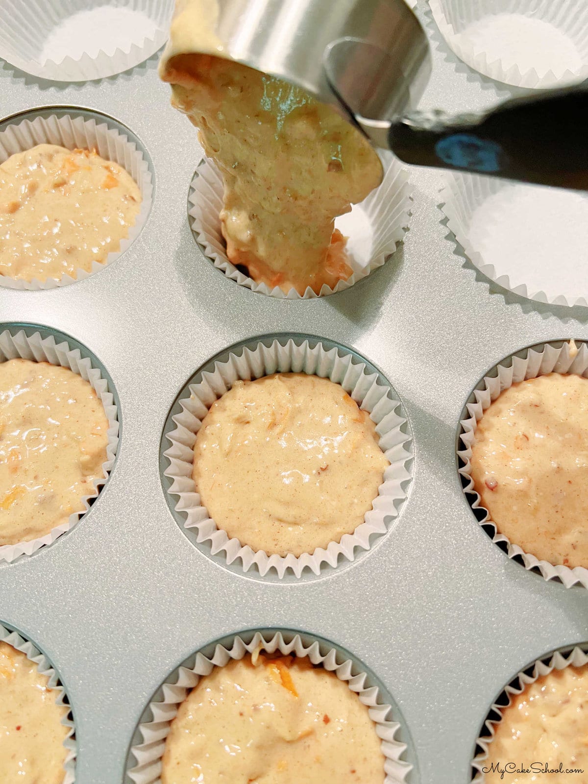 Filling cupcake liners with carrot cupcake batter