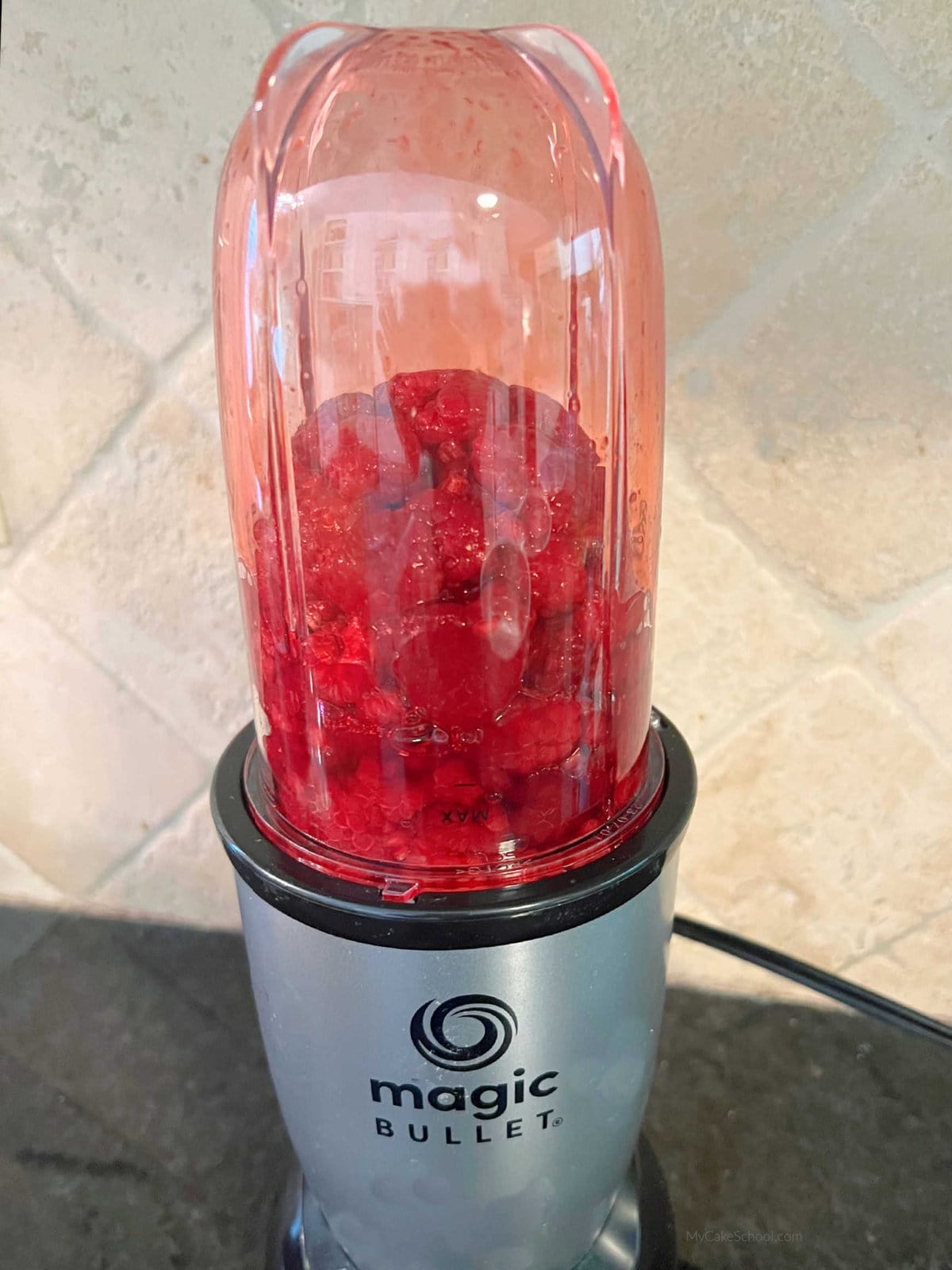 Bullet blender filled with raspberries