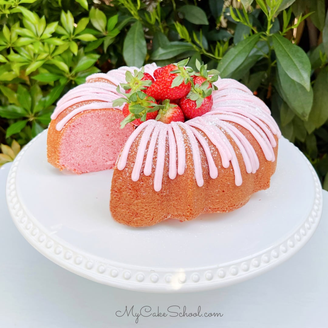 Sliced Strawberry Bundt Cake on a white pedestal