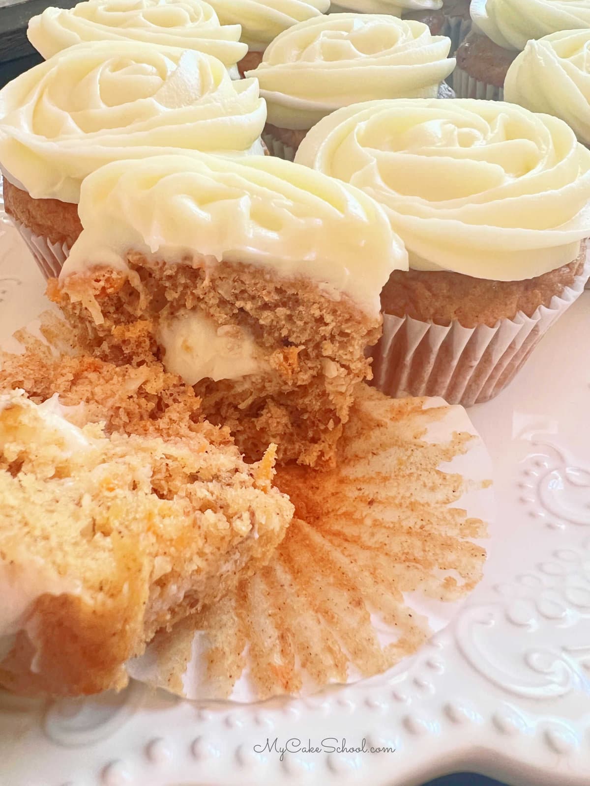 Filled carrot cupcake, sliced in half to expose the cream cheese filling