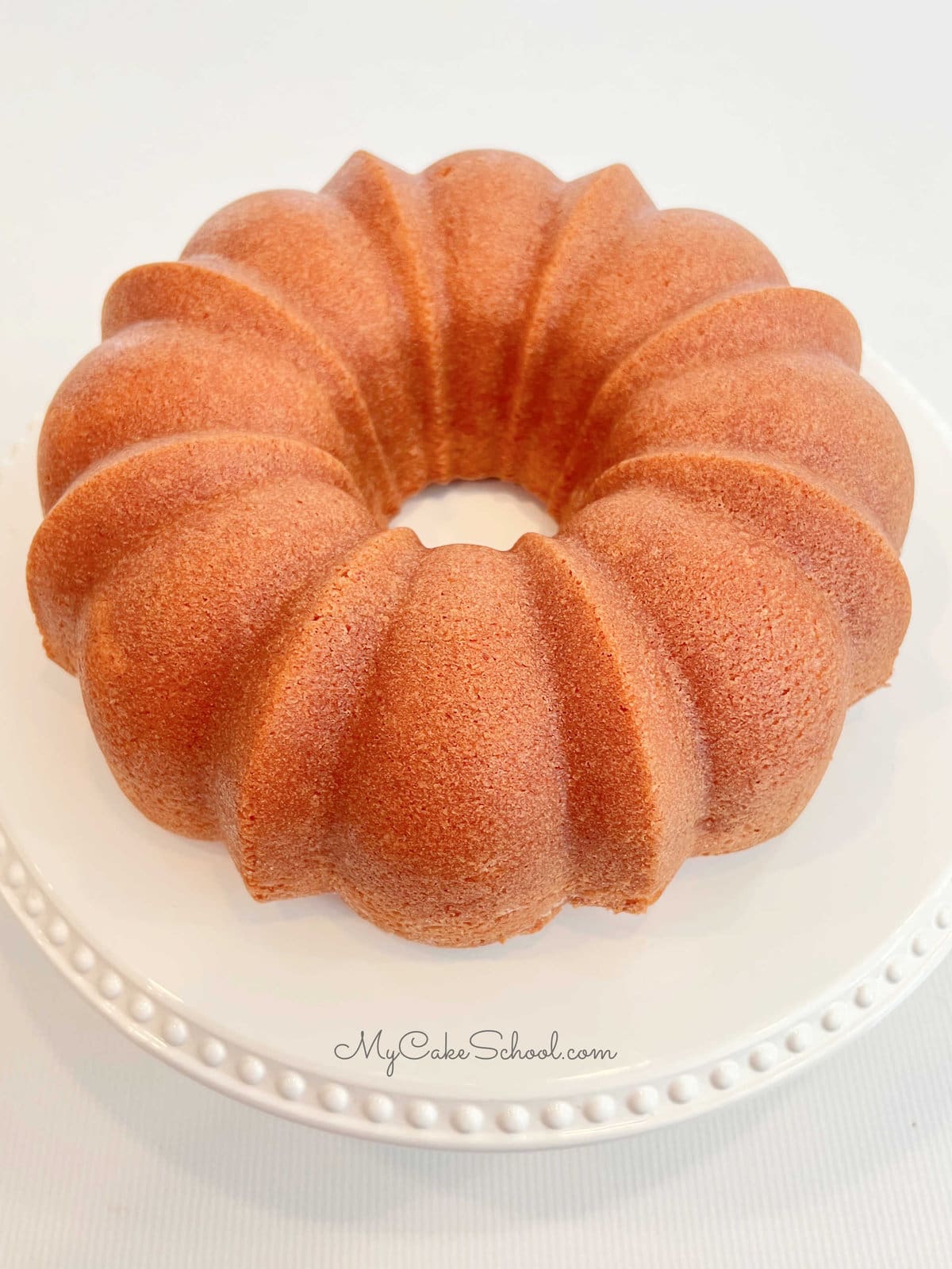 Freshly baked bundt cake on a white pedestal