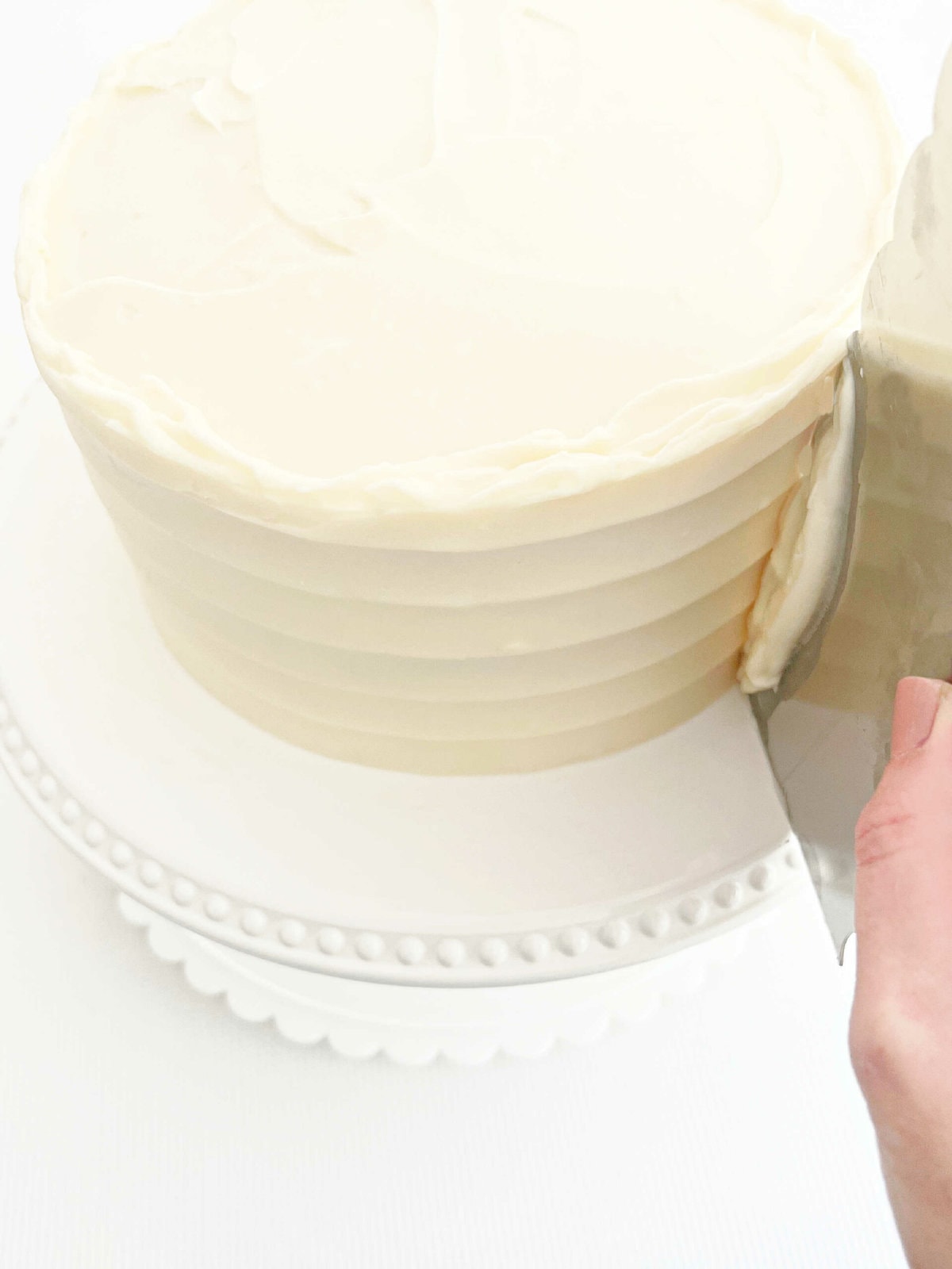 Combing the frosted cake with a cake comb