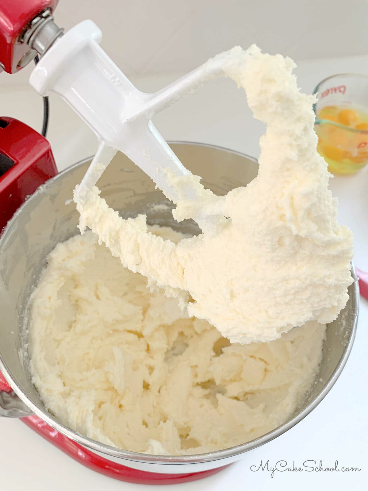 Mixing bowl and paddle attachment with creamed butter and sugar.