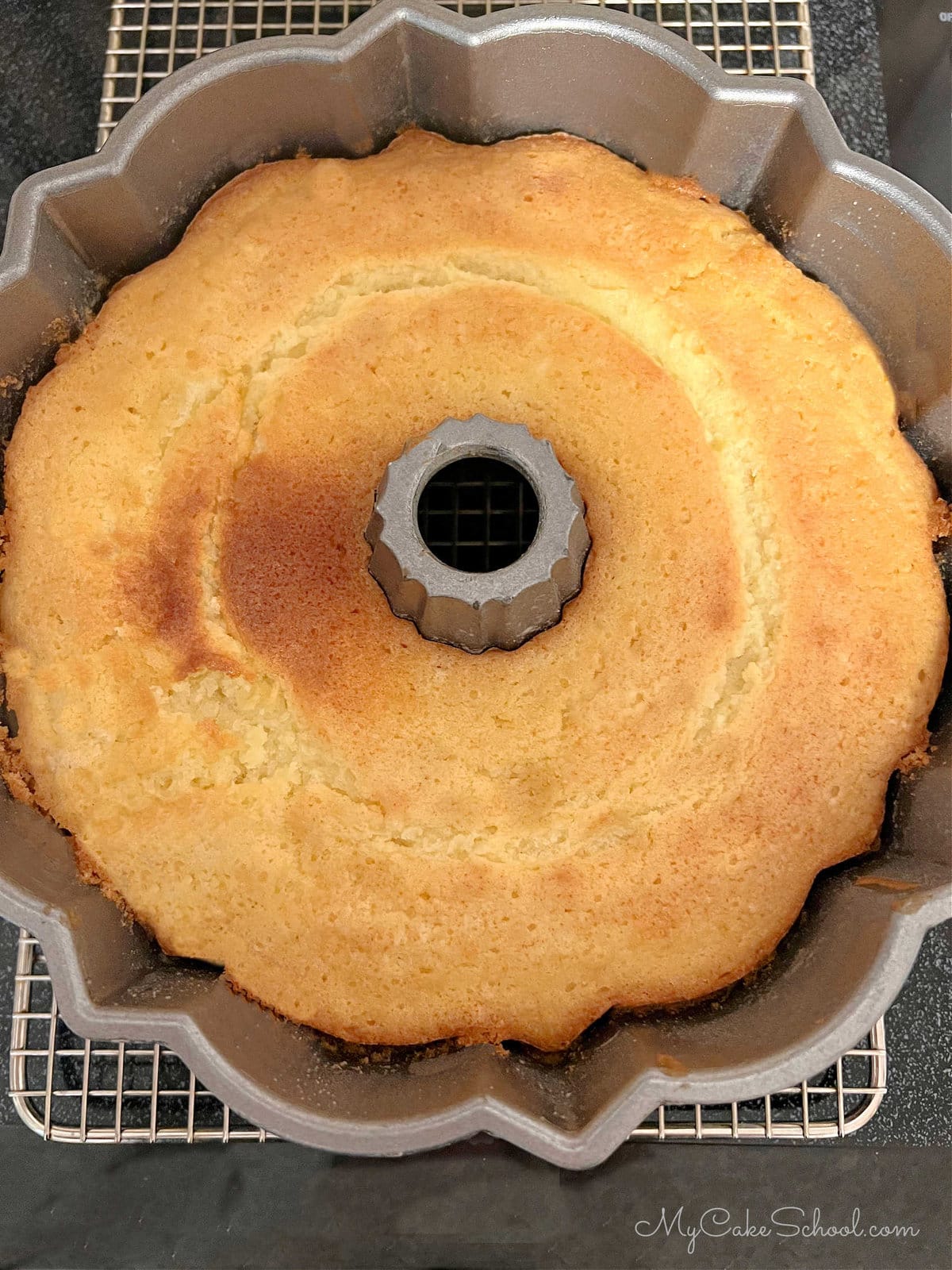 Freshly baked Lemonade Cake in pan on cooling rack