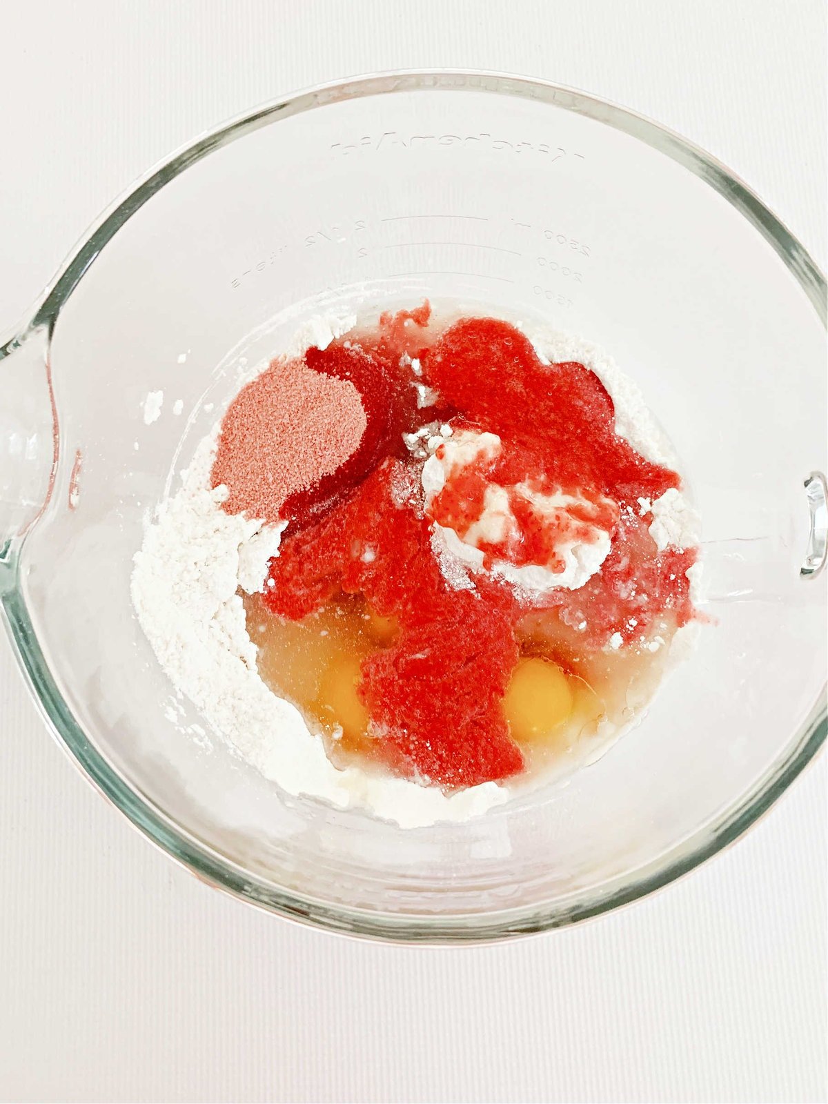 Bowl filled with strawberry cupcake batter ingredients