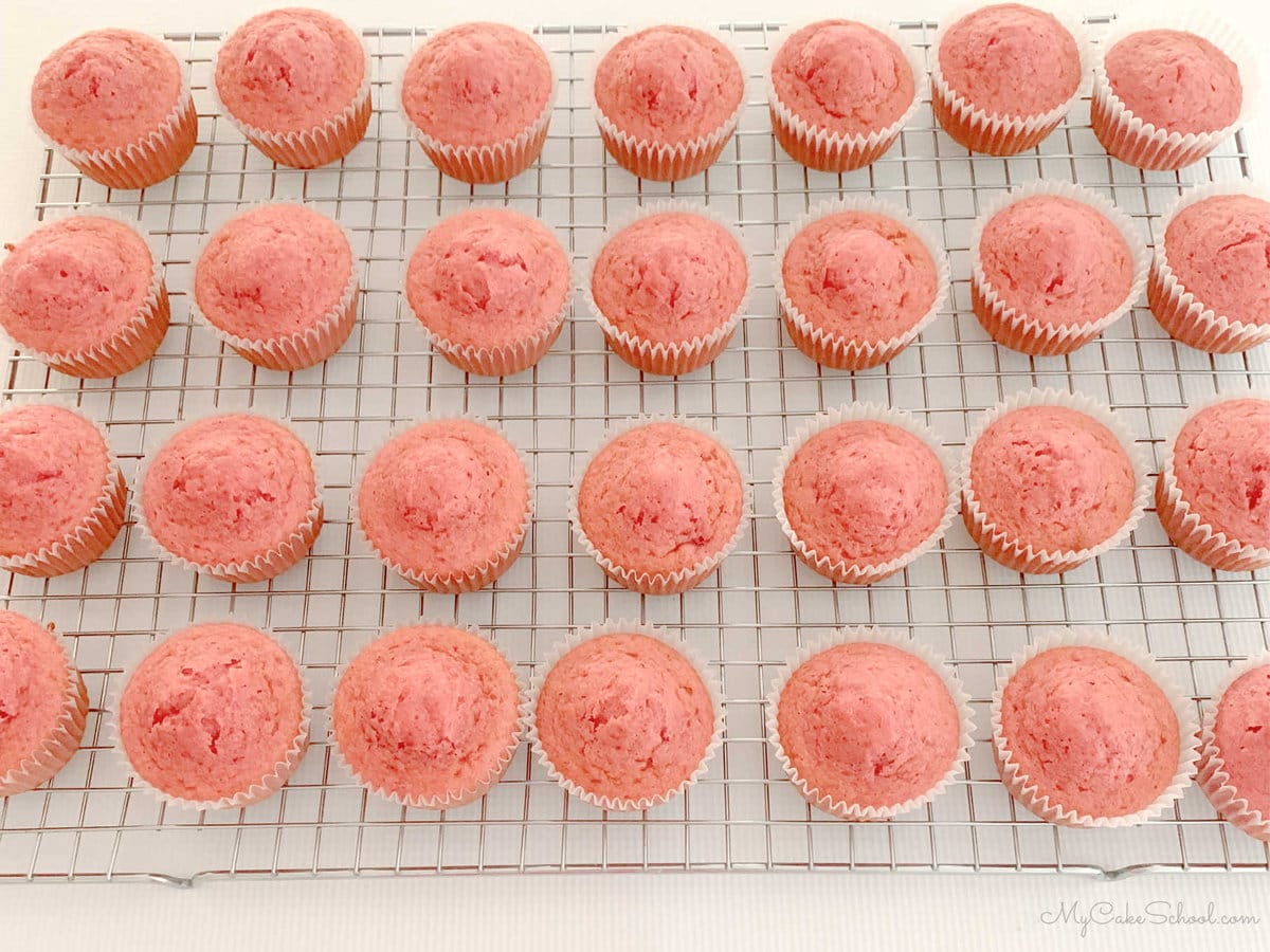 Cooling rack topped with freshly baked strawberry cupcakes