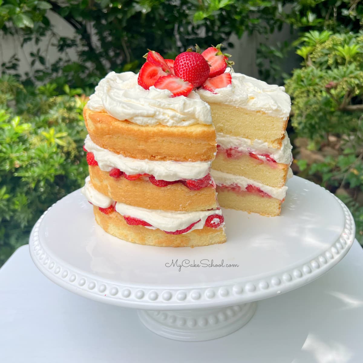 Strawberry Shortcake, sliced on a white pedestal