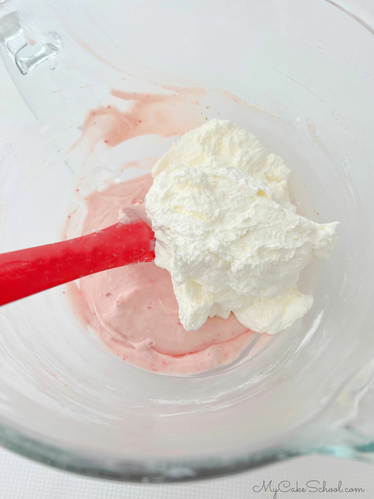 Bowl of whipped cream and strawberry cream cheese mixture for the whipped cream cheese frosting.