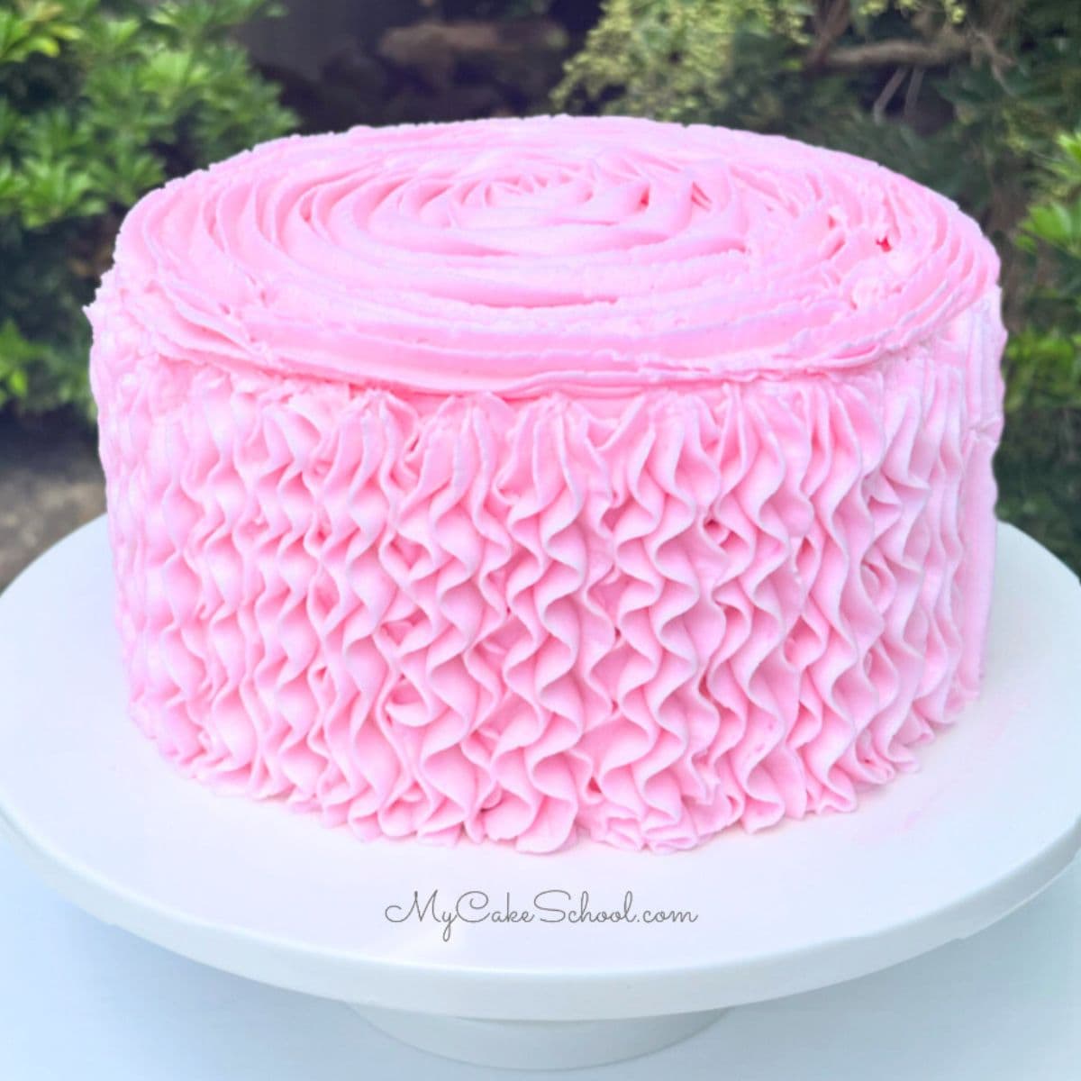 Cake decorated with pink buttercream ruffles, piped with a 1M tip.