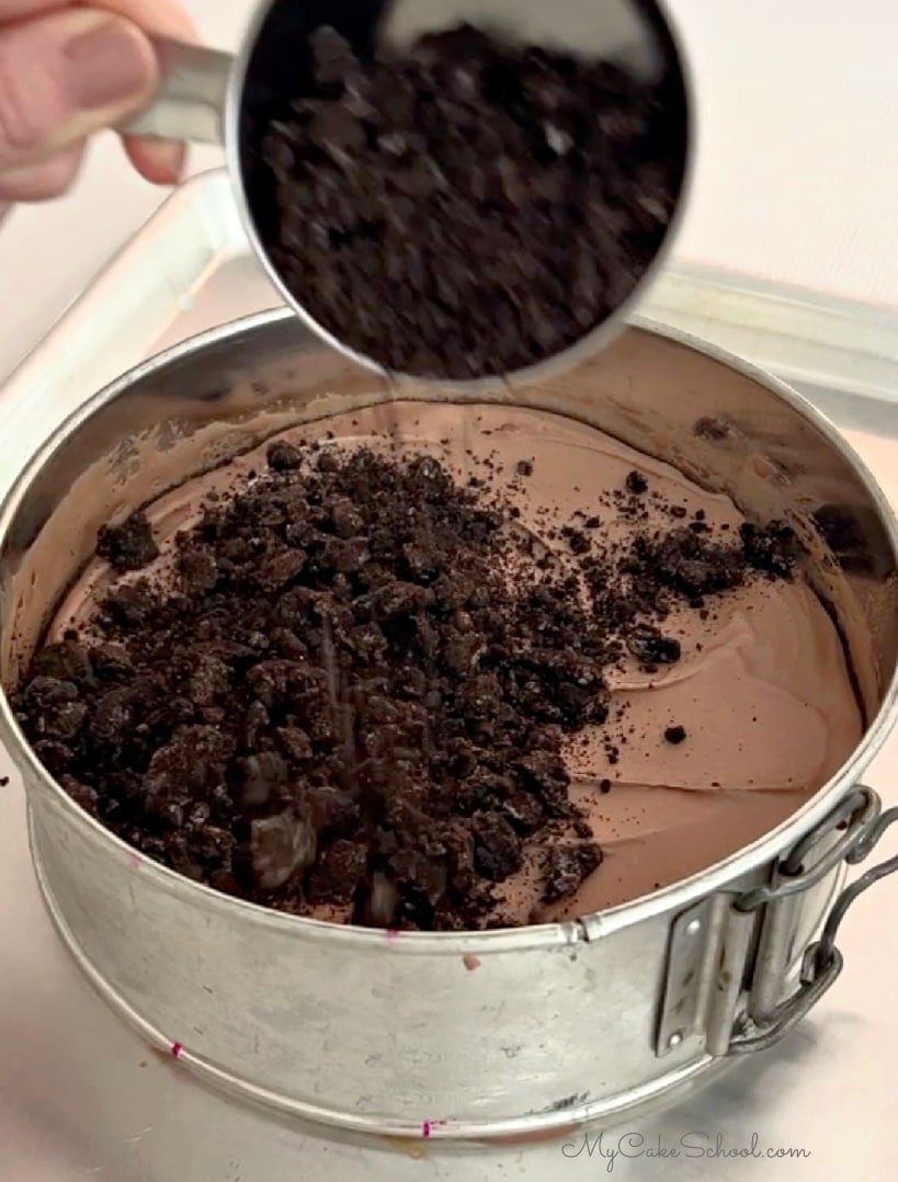 Adding crushed Oreos over layer of chocolate ice cream