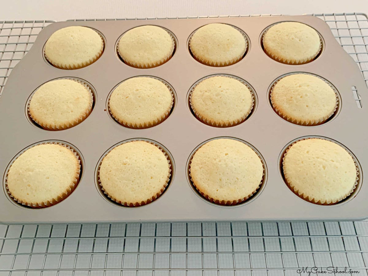 Freshly Baked Lemon Cupcakes in a cupcake pan on a cooling rack