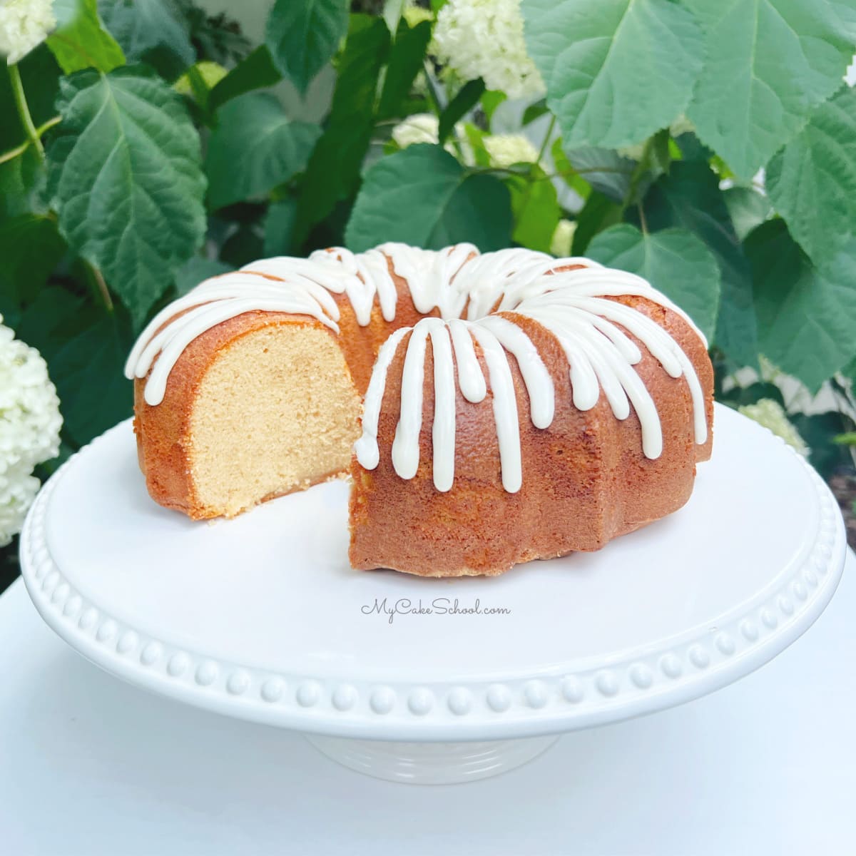 Honey Cake, sliced on a white pedestal with honey glaze
