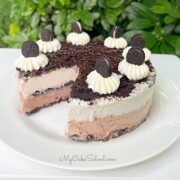 Oreo Ice Cream Cake on white platter, sliced.