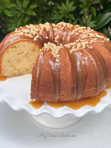 Sliced Toffee Pecan Bundt Cake on a white pedestal