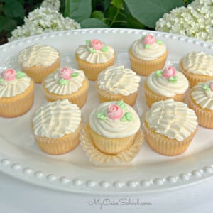 Platter of vanilla cupcakes with vanilla frosting (piped with ruffles and roses)